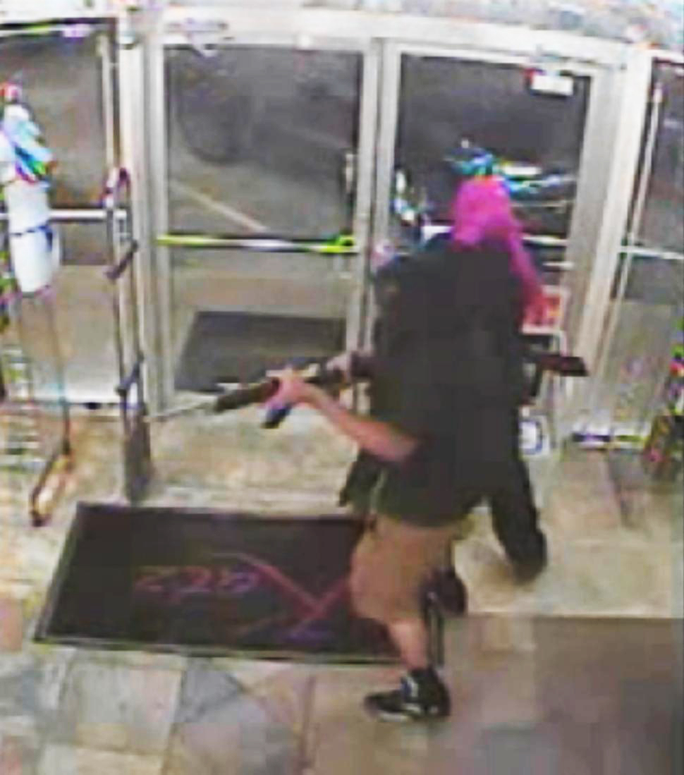 Caught on cam: Clumsy robbers bump into each other, fire shots in lingerie store