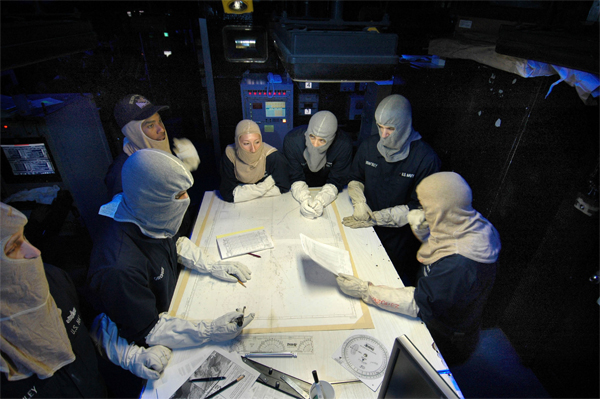 “General Quarters (G.Q.):” U.S. Navy 051129-N-7883G-005 Combat Direction Center (CDC) watch standers plot a chart during a general quarters (GQ) drill held aboard the conventionally powered aircraft carrier USS Kitty Hawk